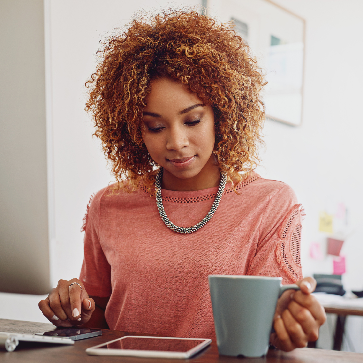 Woman feeling tired at her desk with coffee during an afternoon energy crash.