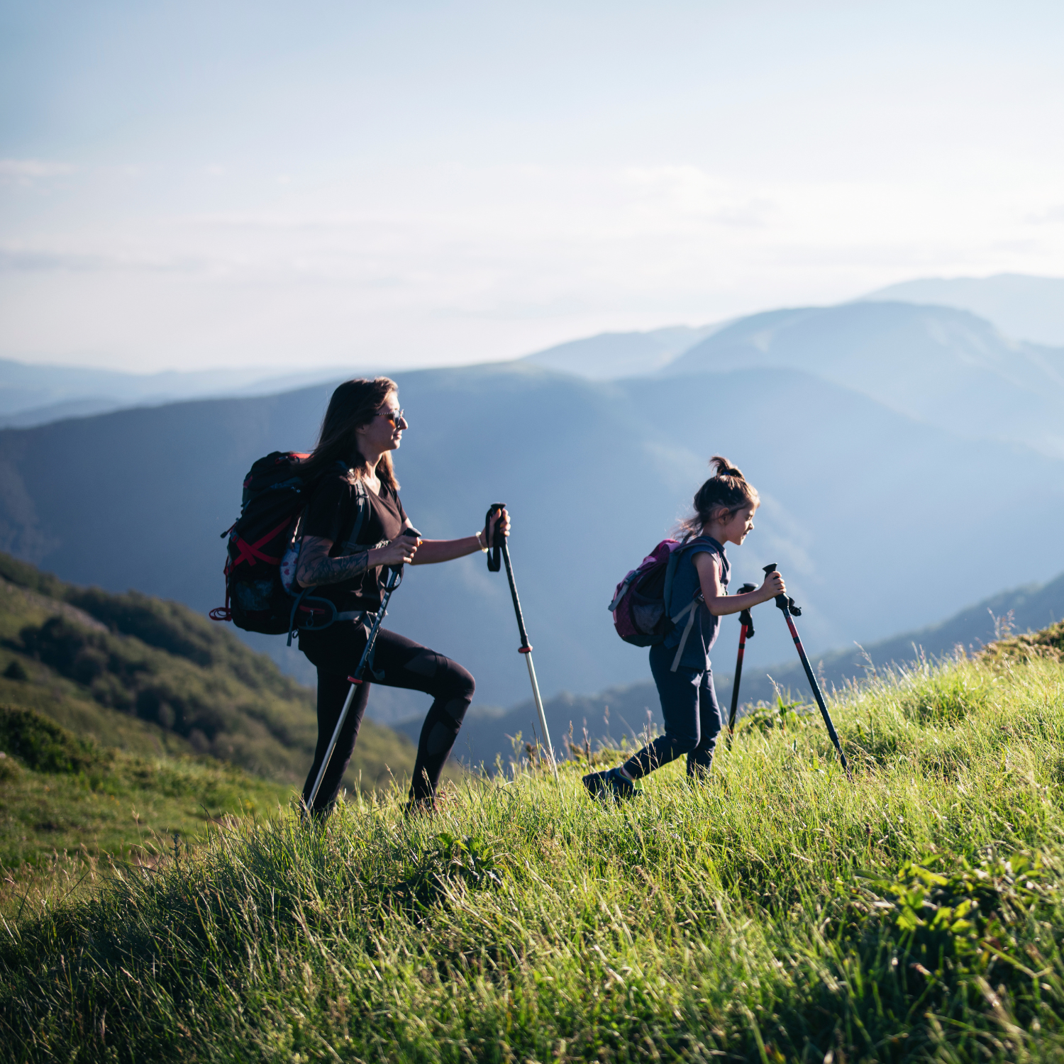Mom and daughter hiking outdoors in nature and natural sunlight to support stress relief and well-being.